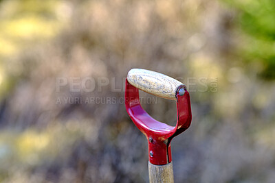 Buy stock photo Closeup of wooden shovel in a garden or field with copy space. Zoom in on macro details, patterns and shape of a gardening tool ready to be used for digging. Macro details of a spade in the ground 