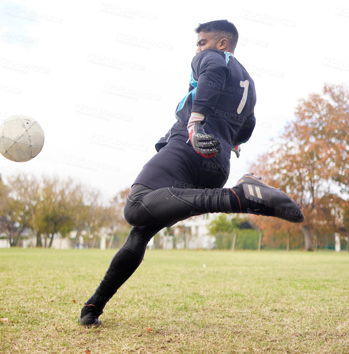 Buy stock photo Shot of a young man playing soccer on a field