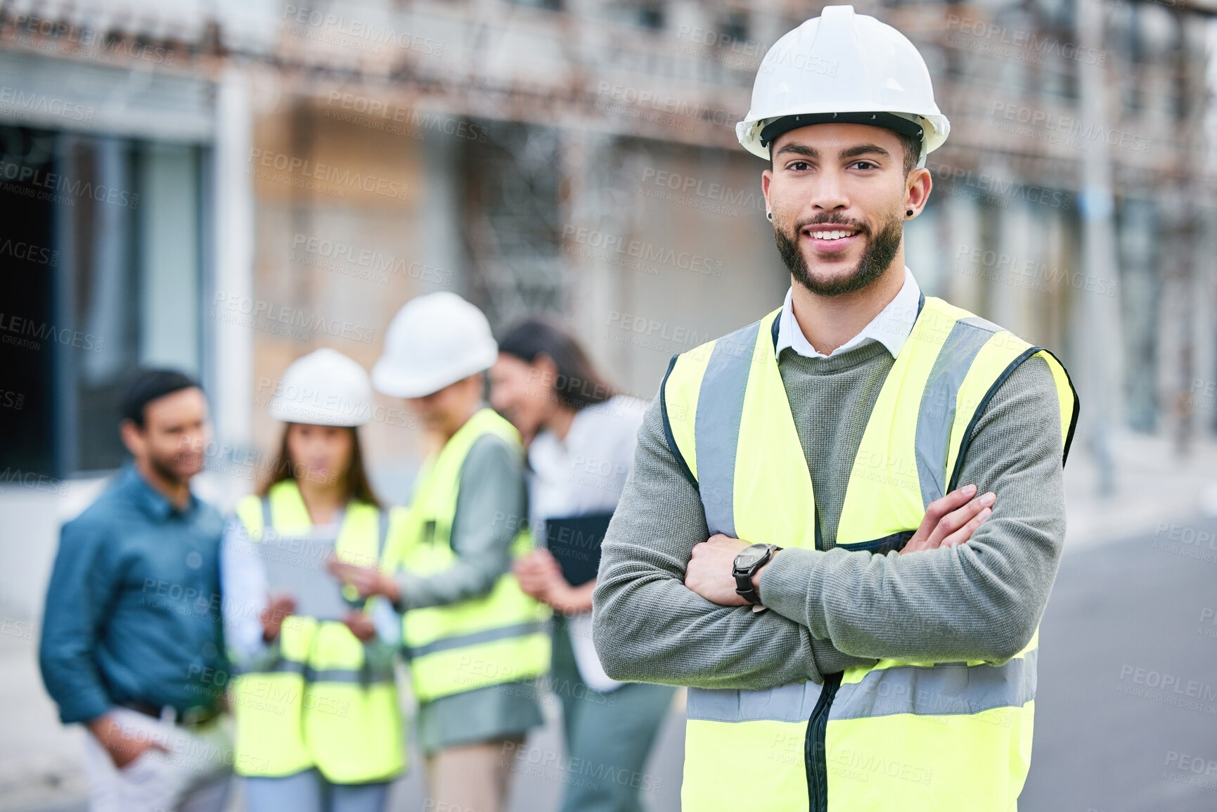 Buy stock photo Shot of a handsome male construction worker standing with his arms folded outside