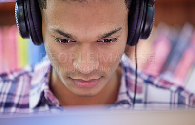 Buy stock photo Student, man and online with headphones in library for concentration, studying and learning knowledge for test or exam. Scholar, internet and reading with music or podcast, education and university.