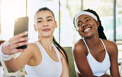 Buy stock photo Cropped shot of two attractive young female tennis players taking selfies in their clubhouse