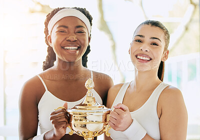 Buy stock photo Cropped portrait of two attractive young female tennis players holding a trophy while standing in the clubhouse during their award ceremony