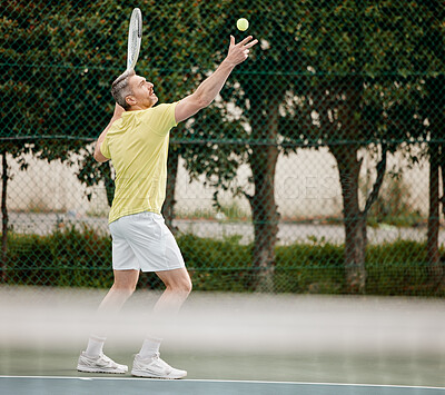 Buy stock photo Full length shot of a handsome mature male tennis player serving during his match