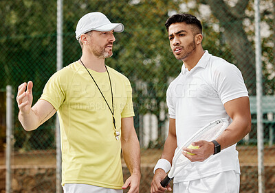 Buy stock photo Cropped shot of a handsome male coach giving instructions to his younger tennis student on a court