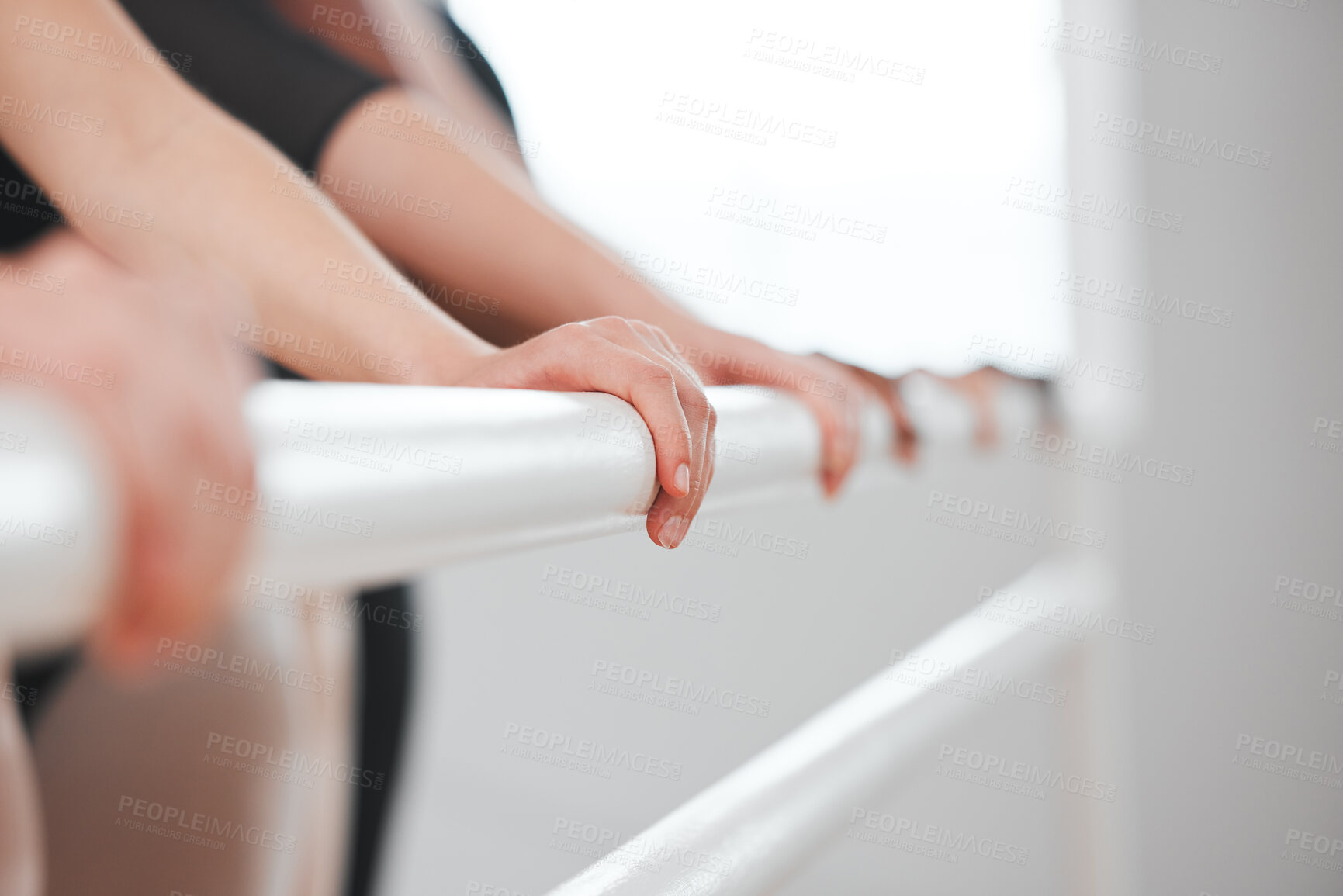 Buy stock photo Shot of a group of ballet dancers leaning against a barre