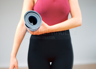 Buy stock photo Shot of a woman holding a yoga mat about to take a class
