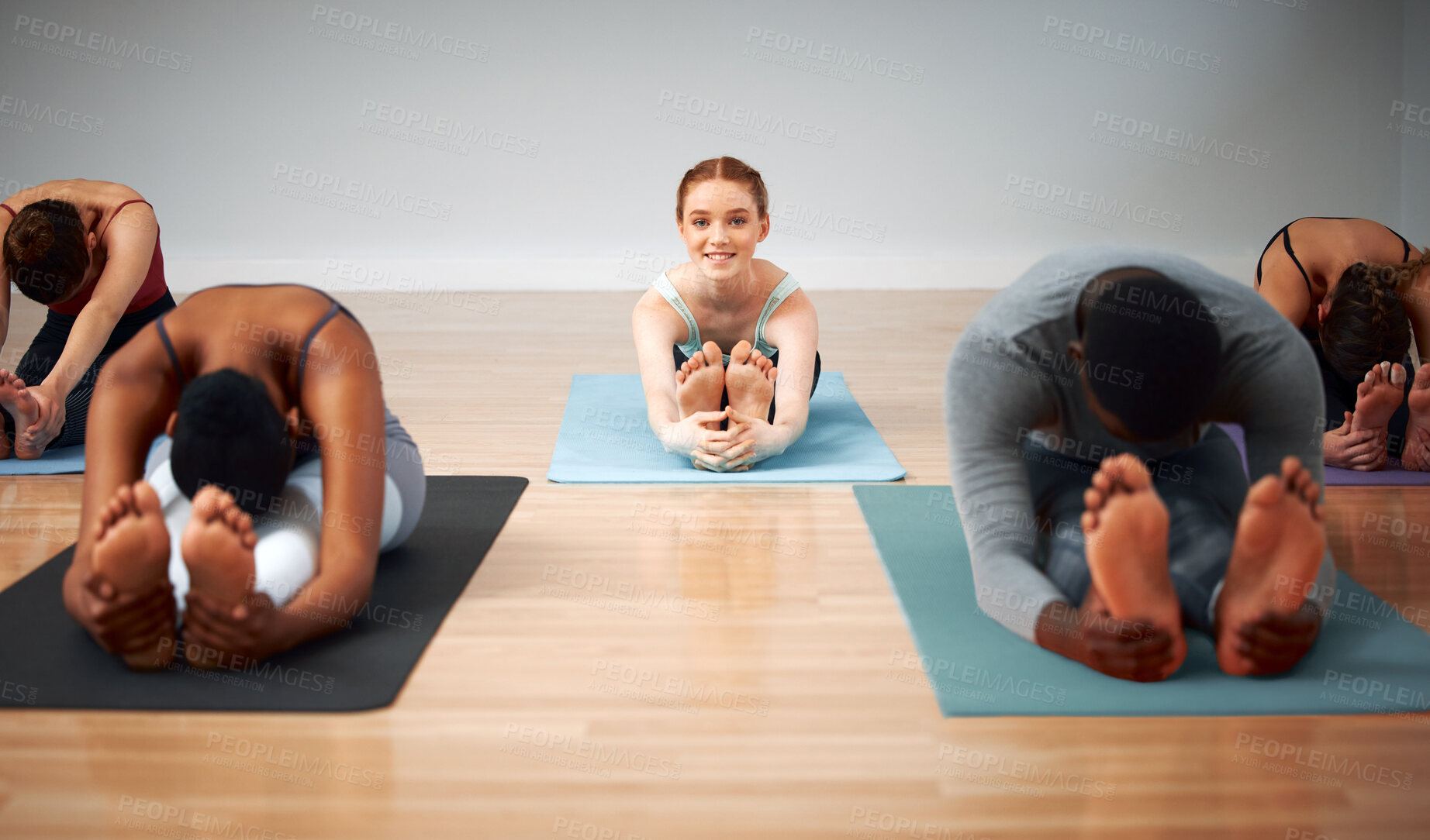 Buy stock photo Shot of a group of people folding forward during a yoga class