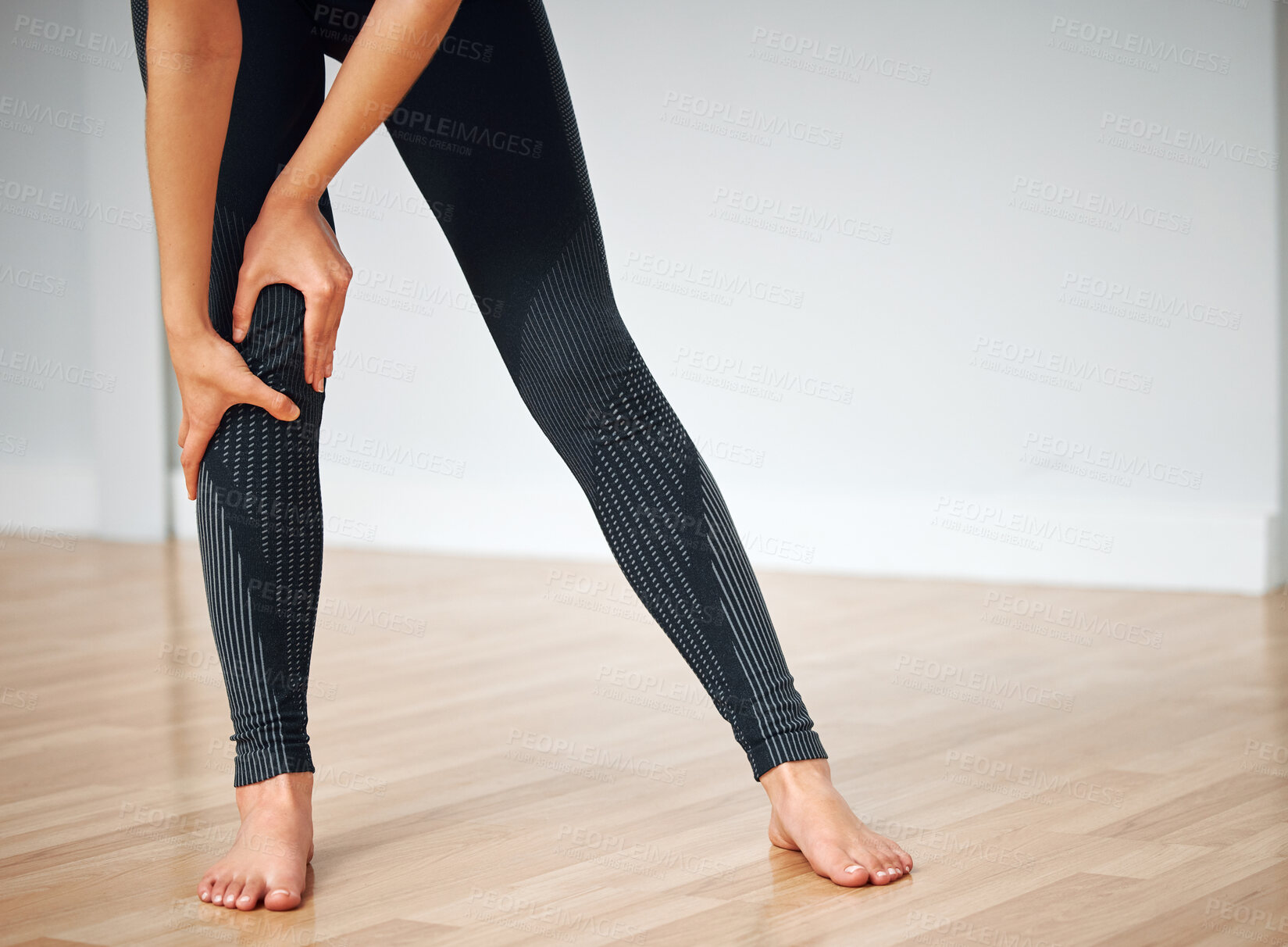 Buy stock photo Shot of a woman inspecting her knee after an injury..