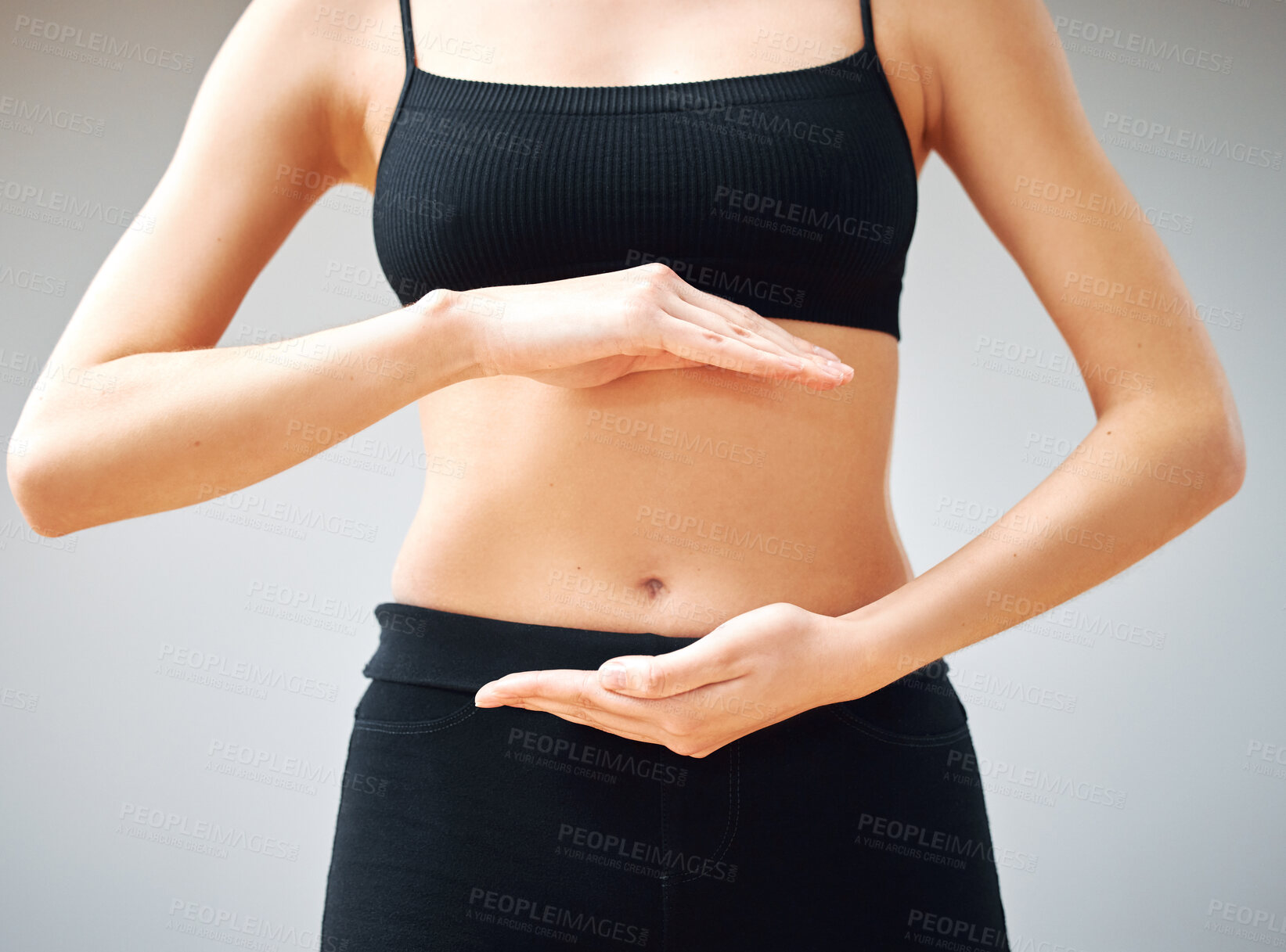 Buy stock photo Shot of a woman forming a circle with her hands in front of her belly