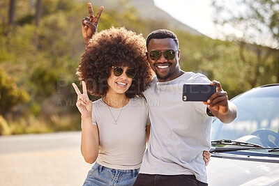 Buy stock photo Shot of a young couple taking a selfie while out on a road trip