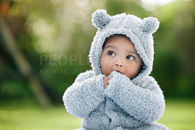 Buy stock photo Baby boy, adorable and cute with jacket in nature for fashion, cotton or furry outfit. Little infant, innocent child or kid thinking in wonder or thought with bear ears for outdoor childhood at park