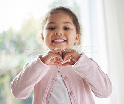 Buy stock photo Girl, child and heart hands in house portrait, love symbol and sign for kindness or peace in lounge. Female person, kid and emoji for support or thank you gesture, home and shape for care or icon