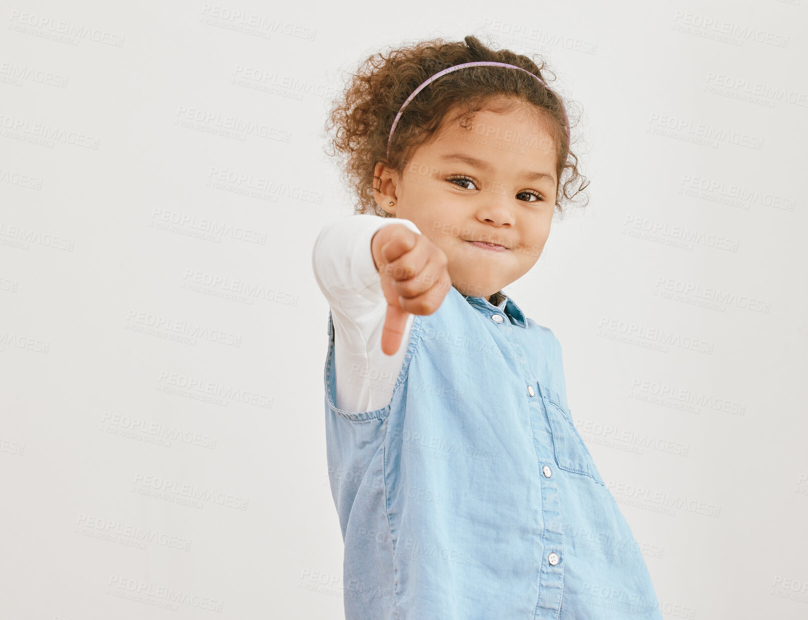 Buy stock photo Girl, kid and thumbs down in studio portrait, negative feedback and review on white background. female person, child and mockup space for rejection rating, dislike emoji and icon for voting fail