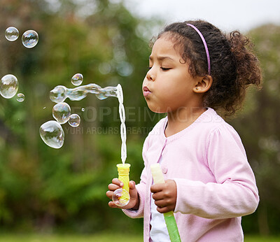 Buy stock photo Girl, child and blowing bubbles in outdoor, backyard fun and toy for playing in countryside garden. Female person, kid and air for liquid soap games at meadow park on weekend, freedom and childhood