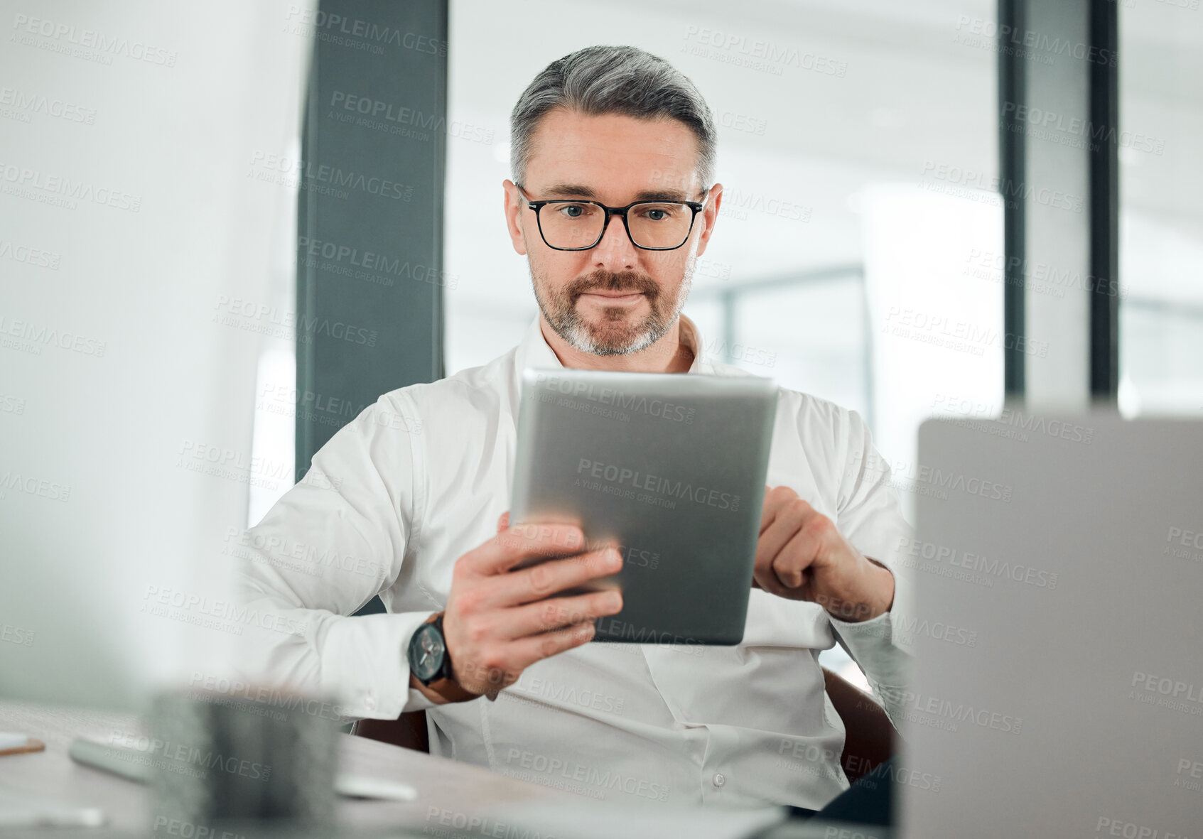 Buy stock photo Mature man, business and tablet at desk in office for planning research, online report or scroll information. Entrepreneur, digital news and software update for social network, reading review and app