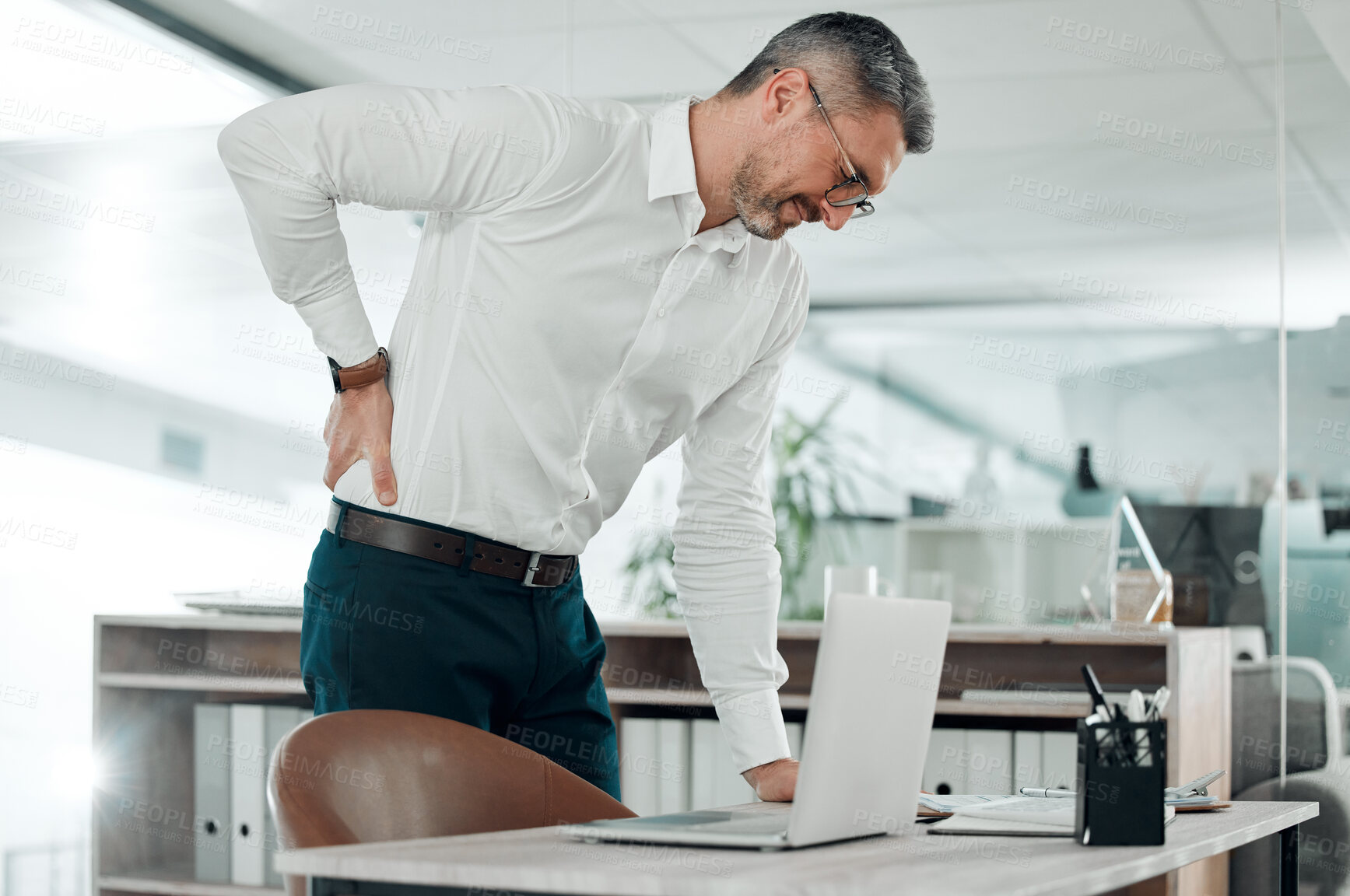 Buy stock photo Office, back pain and man with business, injury and consultant with stress, burnout and overworked. Senior person, employee and entrepreneur with laptop, anxiety and agent with accident and tension
