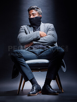 Buy stock photo Gangster, criminal and man with fashion in chair on studio, dark background or thinking of power. Serious, person and cool style with mask on face with mob secret, danger or character in mafia crime