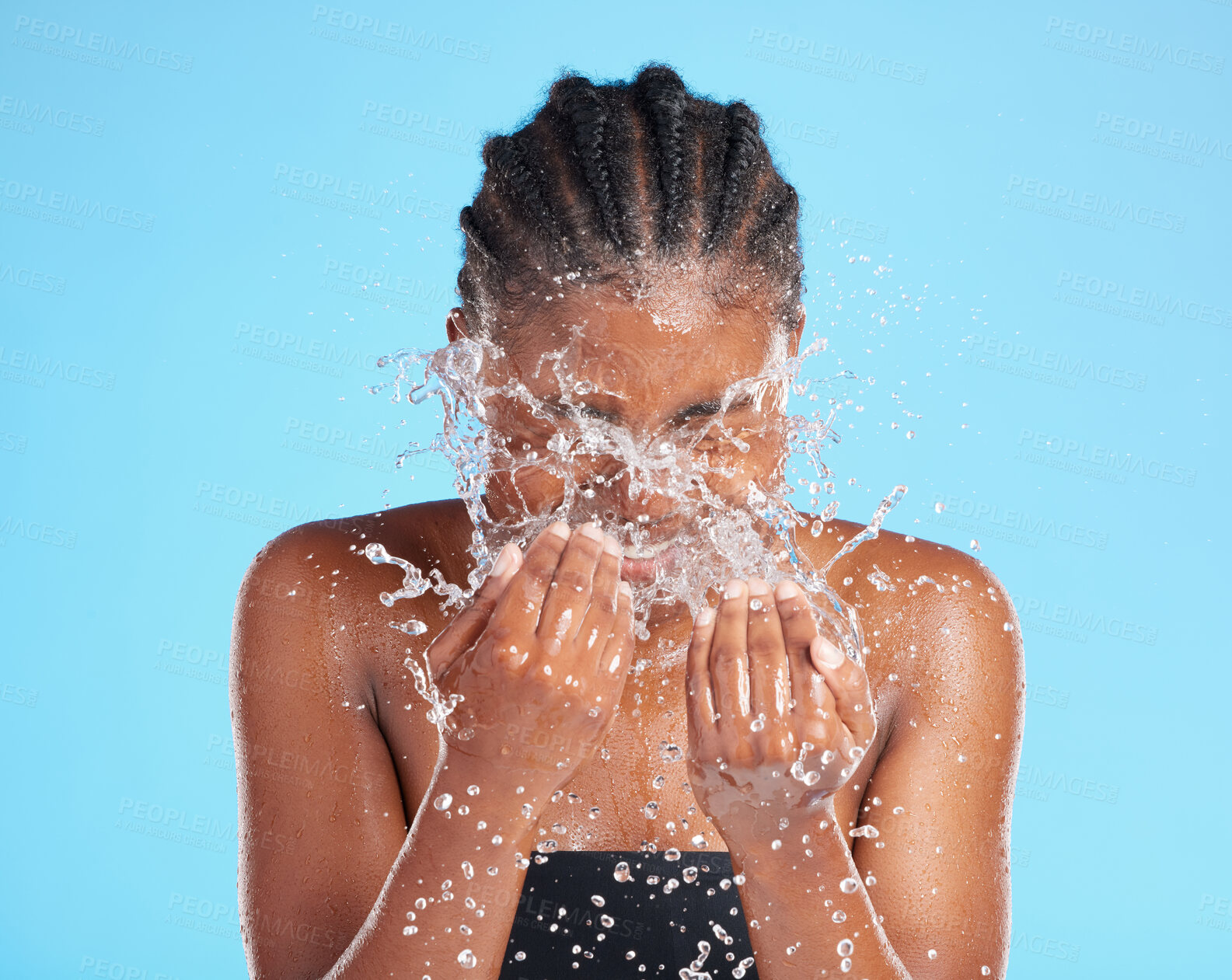 Buy stock photo Black woman, splash and water for cleaning face with hygiene, skincare and beauty care of hydrate glow. Studio, female person and natural facial, organic cosmetics and wellness on blue background