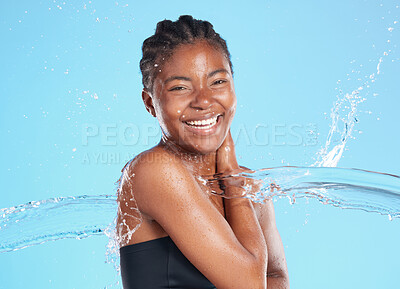 Buy stock photo Portrait, black woman and splash water in studio for cleaning face, hygiene and skincare beauty of hydrate glow. Smile, female person and natural facial, cosmetics and wellness on blue background