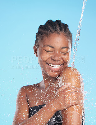 Buy stock photo Black woman, happy and splash of water in studio for cleaning face, hygiene and skincare beauty of hydrate glow. Smile, female person and natural facial, cosmetics and wellness on blue background