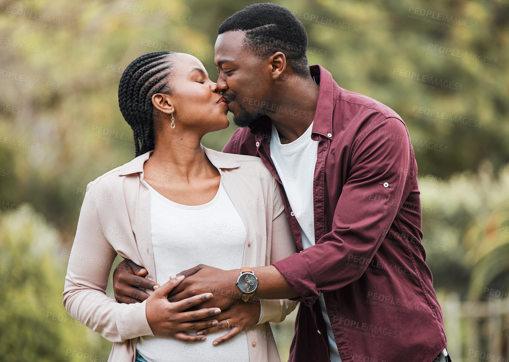 Buy stock photo Black couple, kiss and happy outdoor for pregnancy, bonding and relationship with stomach growth. Man, romance and embrace pregnant woman in home backyard for love, support and maternity in marriage