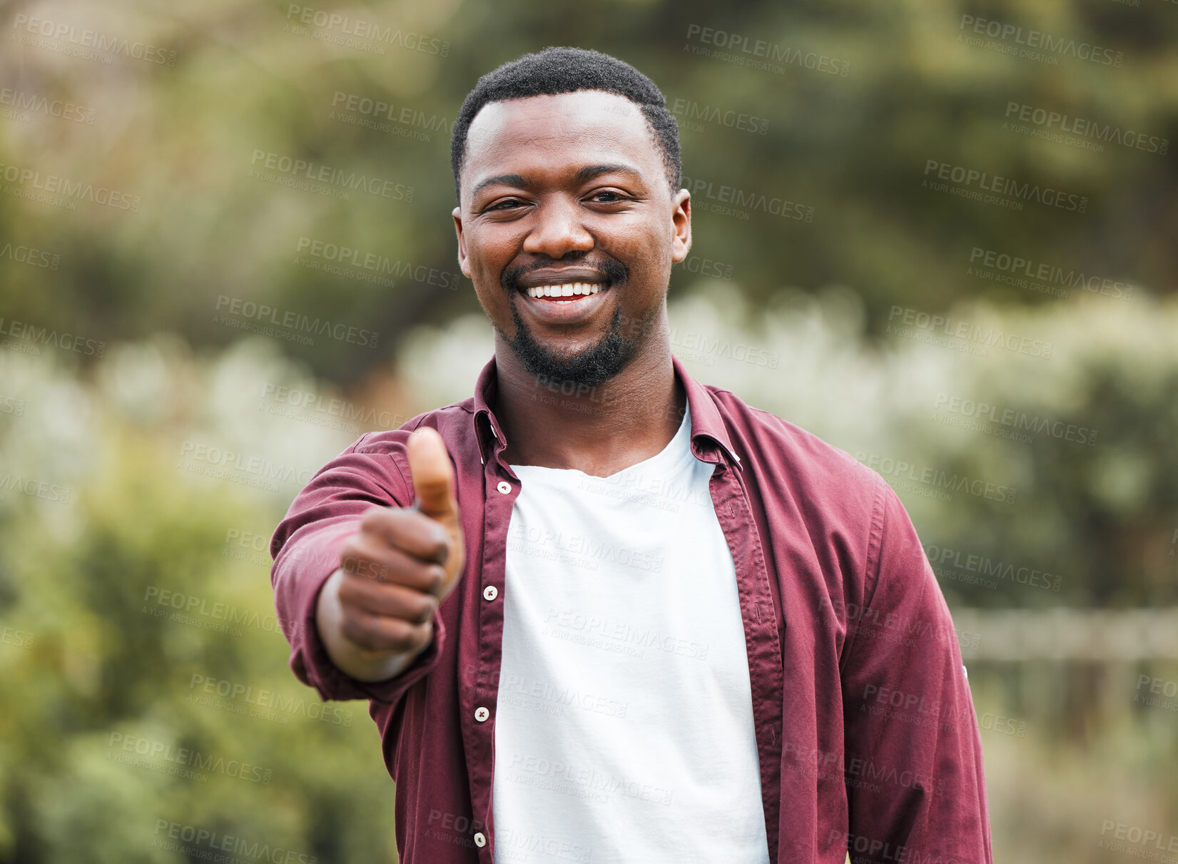 Buy stock photo Shot of a young man giving the thumbs up in his yard