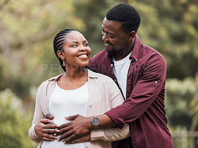 Buy stock photo Shot of a young expecting couple posing together in their yard