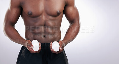 Buy stock photo Cropped shot of an unrecognsiable man standing alone in the studio and holding supplement bottles
