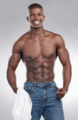 Buy stock photo Shot of a handsome young man standing alone in the studio and posing shirtless
