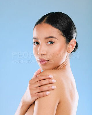 Buy stock photo Shot of an attractive young woman posing topless against a blue  background