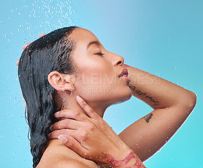 Buy stock photo Studio shot of an attractive young woman showering against a blue background