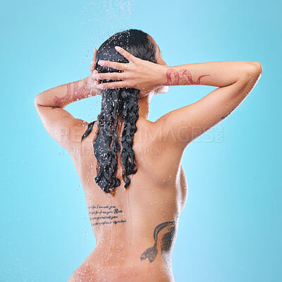 Buy stock photo Studio shot of an unrecognizable young woman showering against a blue background