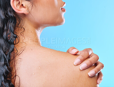 Buy stock photo Studio shot of an unrecognizable young woman showering against a blue background