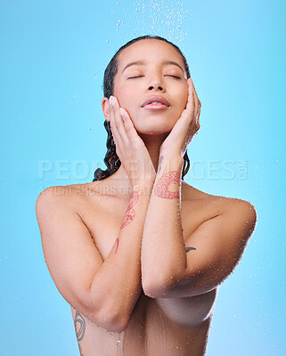 Buy stock photo Studio shot of an attractive young woman showering against a blue background