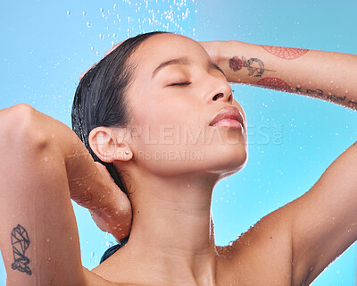 Buy stock photo Studio shot of an attractive young woman showering against a blue background