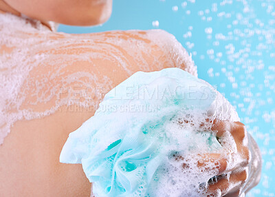 Buy stock photo Studio shot of an unrecognizable young woman showering against a blue background