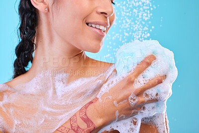 Buy stock photo Studio shot of an unrecognizable young woman showering against a blue background