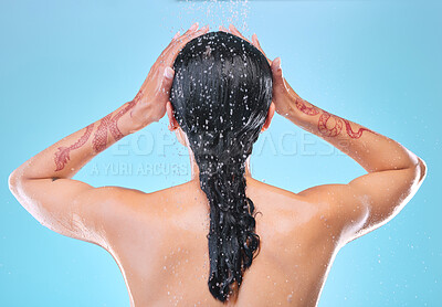 Buy stock photo Studio shot of an unrecognizable young woman showering against a blue background