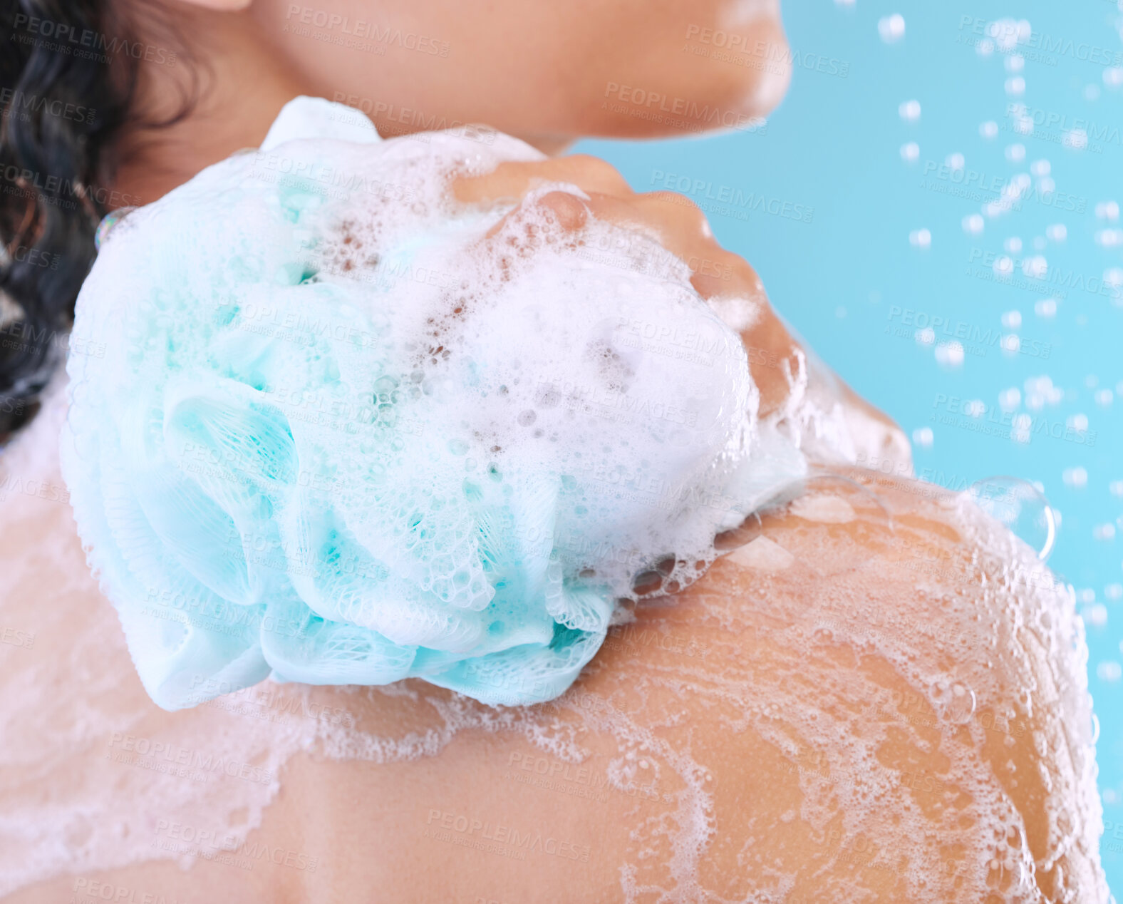 Buy stock photo Hand, sponge and shower for hygiene in studio with foam, skincare and routine by blue background. Person, model and cleaning with grooming, soap and scrub by water drops for wellness to stop bacteria