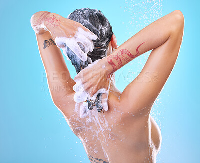 Buy stock photo Studio shot of an unrecognizable young woman showering against a blue background