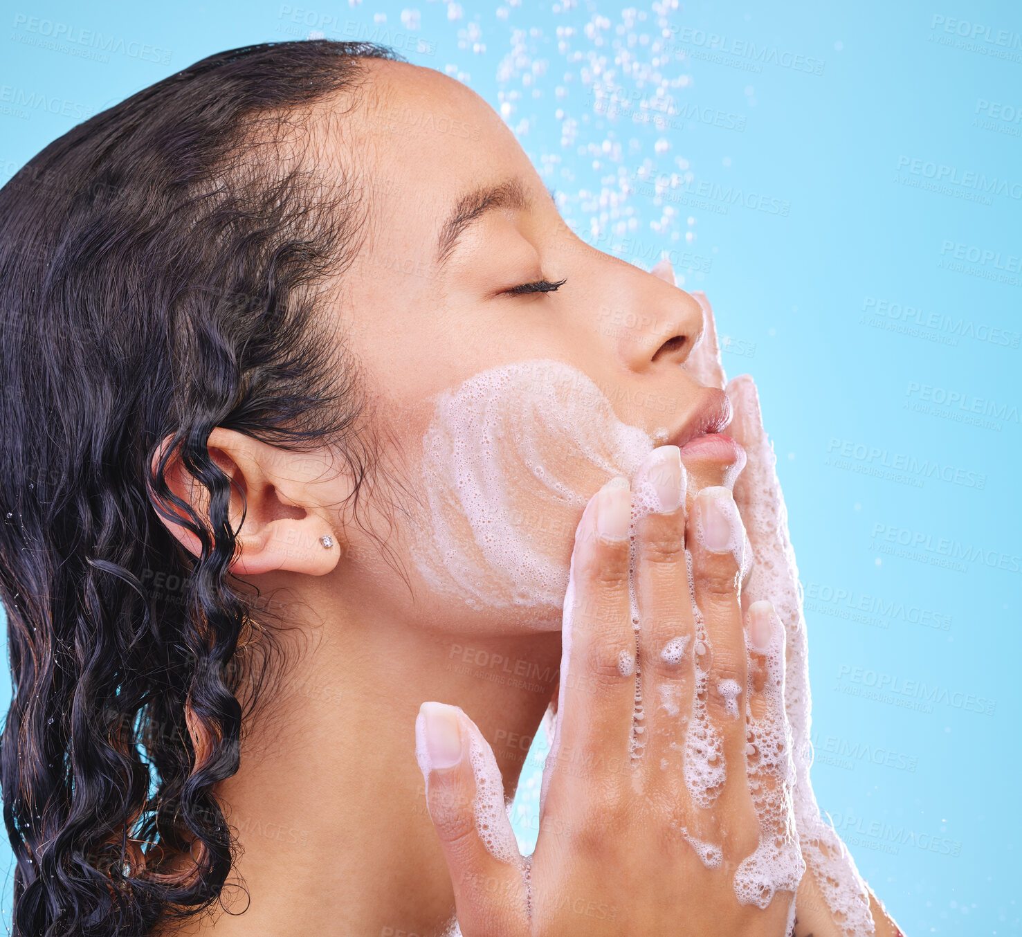 Buy stock photo Face, woman and soap to shower in studio for skin cleaning, body care and hygiene with skincare. Person, morning routine and grooming in bathroom with bathing, water and wellness on blue background