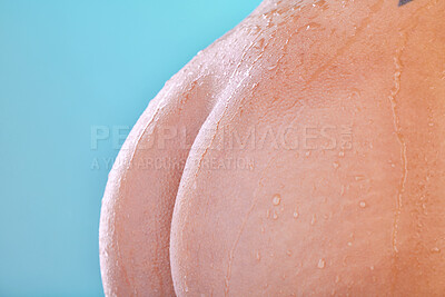 Buy stock photo Studio shot of an unrecognizable young woman showering against a blue background