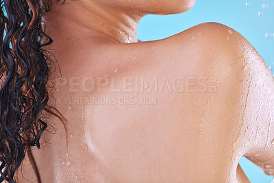 Buy stock photo Studio shot of an unrecognizable young woman showering against a blue background