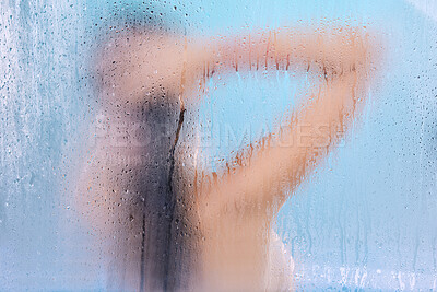 Buy stock photo Studio shot of an unrecognizable young woman showering against a blue background