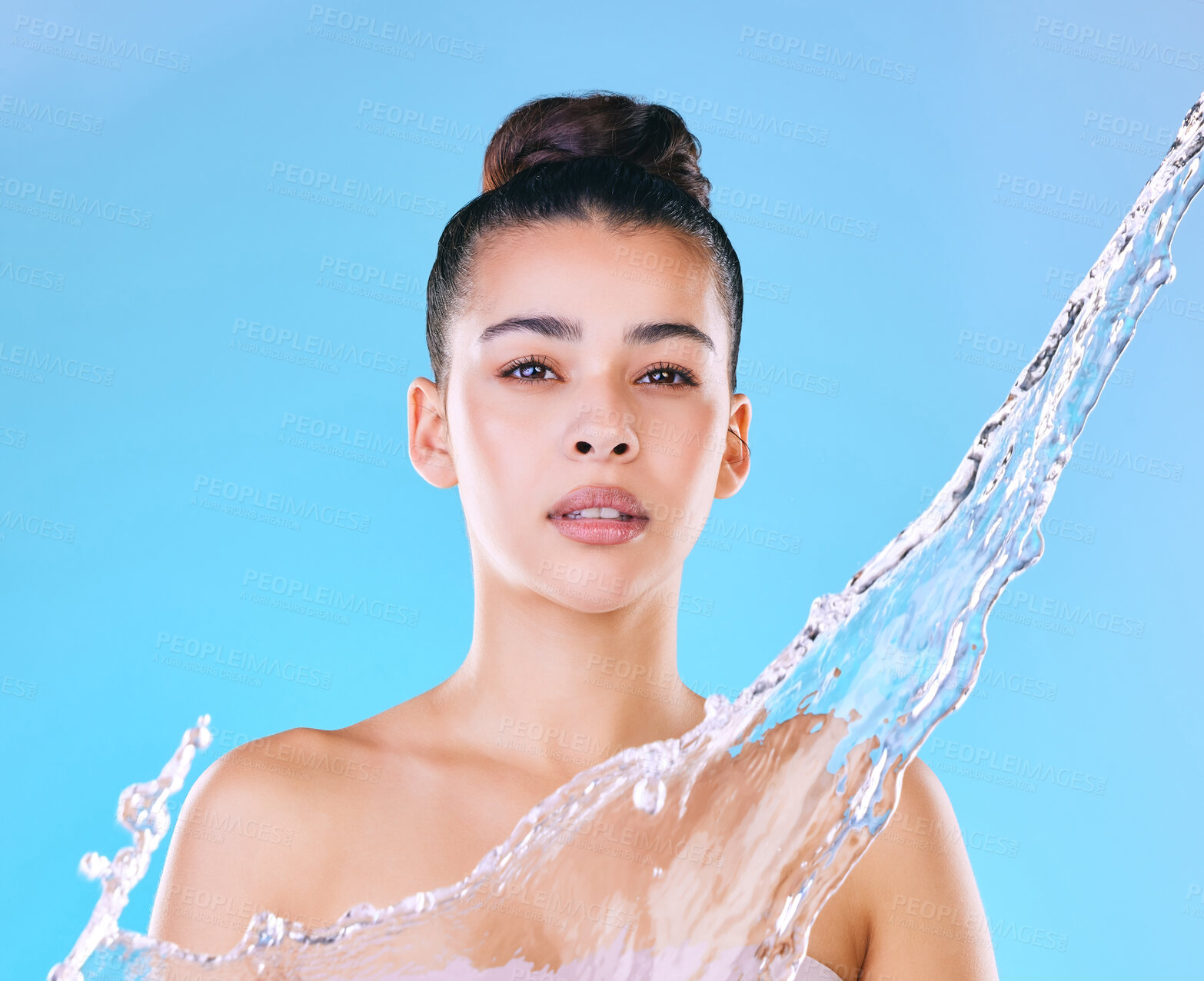 Buy stock photo Water, splash and portrait of woman in studio for natural hydration, cosmetics and skincare. Aqua, shower and female person with pride on blue background for hygiene, cleaning body and dermatology