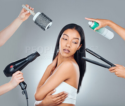 Buy stock photo Studio shot of an attractive young woman surrounded by hairstyling products against a grey background