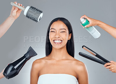 Buy stock photo Studio portrait of an attractive young woman surrounded by hairstyling products against a grey background