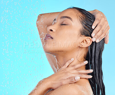 Buy stock photo Shot of an attractive young woman showering against a blue background