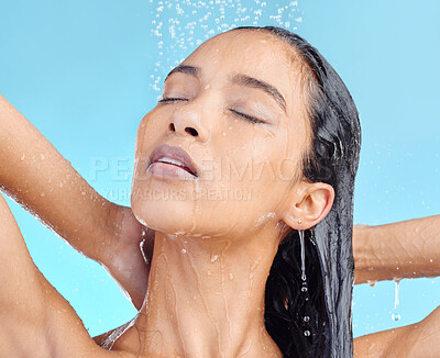 Buy stock photo Shower, cleaning and woman washing hair in studio for beauty, wellness and hygiene on blue background. Haircare, skincare and female model relax in water splash, showering and cleansing isolated