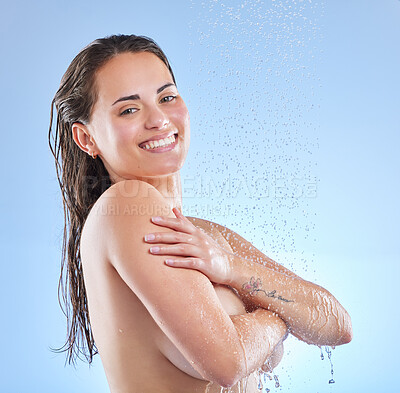 Buy stock photo Shot of a beautiful young woman enjoying a refreshing shower against a blue background